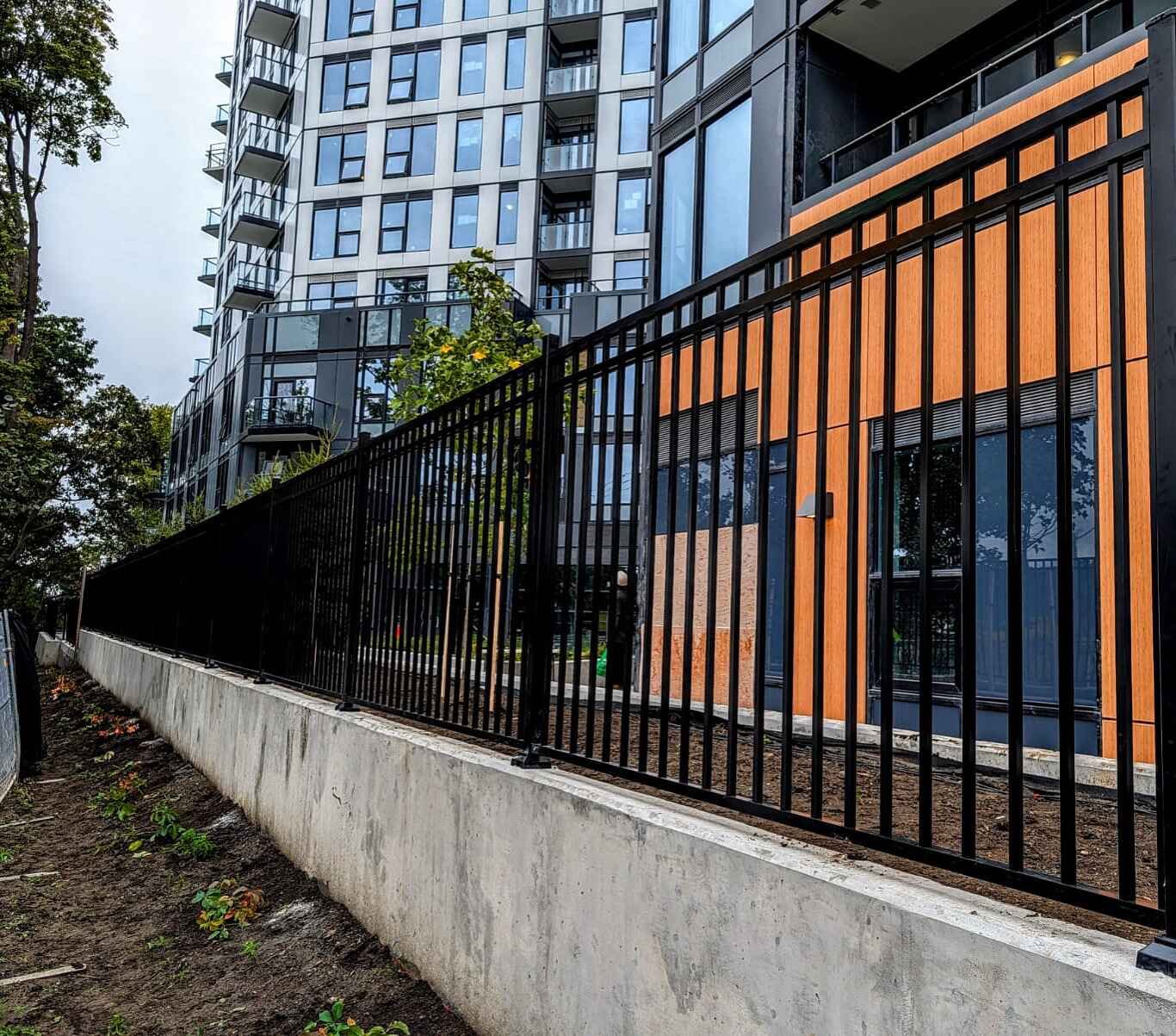 Commercial aluminum picket fence installed on concrete retaining wall
