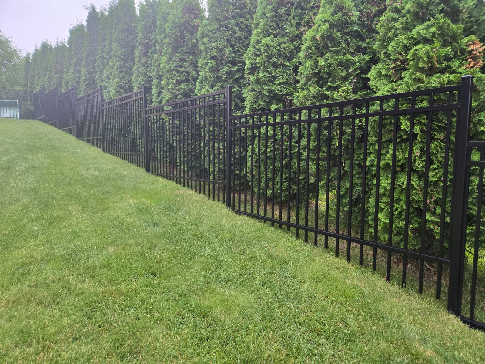 Custom aluminum picket fence using longer pickets to accommodate a large slope