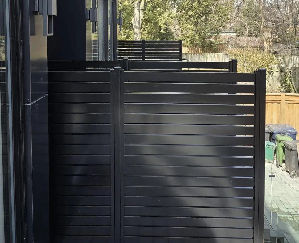 Black aluminum horizontal fence panels around modern deck and yard